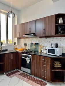 a kitchen with wooden cabinets and a stove top oven at Lomes cozy home in Dar es Salaam