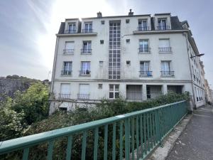 un bâtiment avec une clôture verte devant lui dans l'établissement -Pause Retro- T2 Centre Gare Wifi Lave Linge, à Quimper