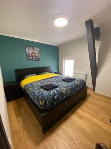 una camera da letto con un letto e pareti gialle e blu di Au cœur du vignoble champenois ad Ay
