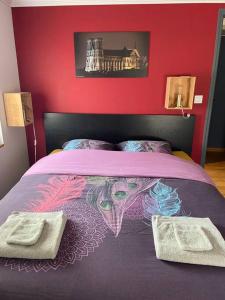 una camera con letto viola e parete rossa di Au cœur du vignoble champenois ad Ay