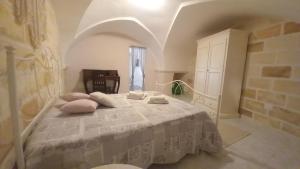 a bedroom with a white bed with pillows on it at LILLI'S HOME in Crispiano