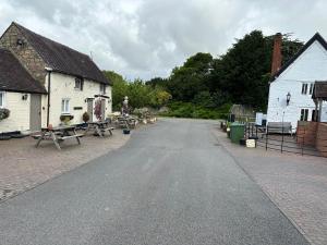 墨爾本的住宿－The Hardinge Arms，两座白色建筑之间一条空路,有野餐桌