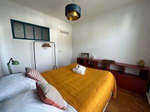 1 dormitorio con 1 cama con 2 almohadas en -Pause Retro- T2 Centre Gare Wifi Lave Linge, en Quimper
