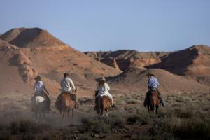 grupa ludzi jeżdżących konno na pustyni w obiekcie Pet Friendly Cabins in Hanksville Utah w mieście Hanksville