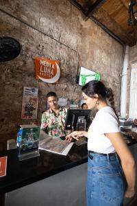 uma mulher em frente a uma caixa registadora em Media Luna Hostel Cartagena em Cartagena das Índias