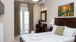 a bedroom with a large white bed and a window at Spilaio at Meteora in Kalabaka +48 photos