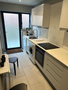 a kitchen with a stove and a sink and a dishwasher at Modern Annex in Kent