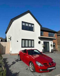 a red car parked in front of a house at Modern Annex in Kent