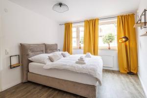 a bedroom with a large bed with yellow curtains at Traumhaftes Domizil mit Tiefgarage in Stade