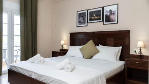 a bedroom with a large bed with white sheets at Spilaio at Meteora in Kalabaka