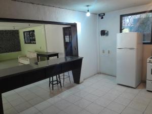 a kitchen with a counter and a white refrigerator at Casa de campo, cerca del aeropuerto internacional del Vacío in Guanajuato