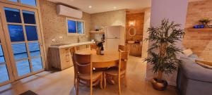 a kitchen with a table and chairs and a refrigerator at Serentias suite & spa in Ein Kinya
