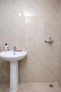 a bathroom with a white sink and a shower at Entire Villa Niku with Beautiful Garden in Vlorë