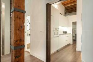 cocina grande con paredes blancas y vigas de madera en Eclectic & elegant apartment by REMS, en Málaga