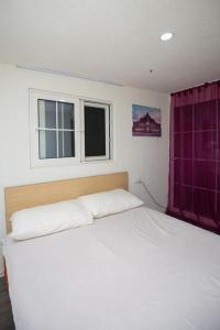 a white bed in a bedroom with a window at Entire Villa Niku with Beautiful Garden in Vlorë