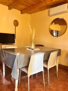 a dining room table with white chairs and a mirror at Wara in Cafayate