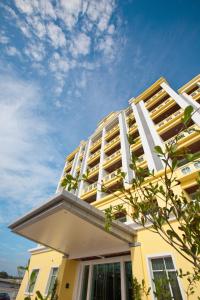 un edificio amarillo con balcones blancos encima en Jinhold Apartment Hotel, en Bintulu