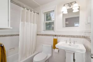 ポートランドにあるLovely Laurelhurst Livingのトイレと洗面台を備えた白いバスルーム +22枚の写真