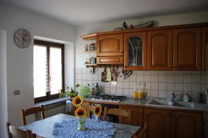 a kitchen with wooden cabinets and a table with sunflowers on it at VILLA ADRY Mon Reve Holidays in Aosta