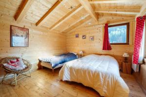 ein Schlafzimmer in einem Blockhaus mit einem Bett und einem Stuhl in der Unterkunft La turra in Lanslebourg-Mont-Cenis