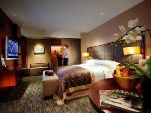 Crowne Plaza Beijing Zhongguancun, an IHG Hotel في بكين: امرأة تقف في غرفة الفندق مع سرير