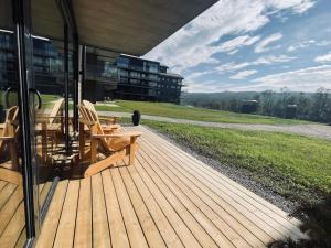 - une terrasse en bois avec 2 chaises au-dessus d'un bâtiment dans l'établissement Highland Lodge Fjellandsby - 3105, à Geilo