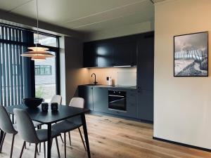 a kitchen with black cabinets and a table and chairs at Highland Lodge Fjellandsby - 3105 in Geilo