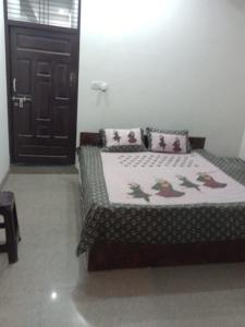 a bedroom with a bed and a black door at Hari Kripa Sadan in Ayodhya