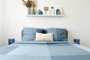Una cama con un edredón azul y una almohada. en Maison avec jardin proche de Paris, en Mormant