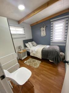 1 dormitorio con 1 cama y 1 silla en Cabañas Alto Centro, Departamento N 2, en La Unión