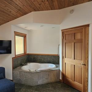 a bath tub in a room with a wooden ceiling at Snug Harbour Inn in Ucluelet
