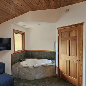 eine Badewanne in einem Zimmer mit Holzdecke in der Unterkunft Snug Harbour Inn in Ucluelet