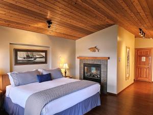 a bedroom with a large bed and a fireplace at Snug Harbour Inn in Ucluelet