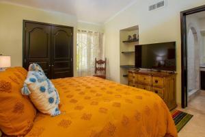 una camera da letto con un letto giallo e una televisione di Casa Vista al Mar a San José del Cabo