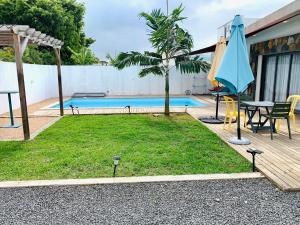 a patio with a table and a blue umbrella at Sunny Side Up in Grand Baie