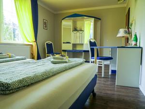 a bedroom with two beds and a table and a mirror at Hotel & Ristorante Positano in Radeburg