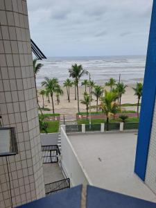 - une vue sur la plage bordée de palmiers et l'océan dans l'établissement Lindo apto em frente ao mar., à Praia Grande
