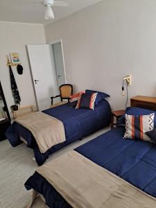 - une chambre avec 2 lits et des couettes bleues dans l'établissement Lindo apto em frente ao mar., à Praia Grande