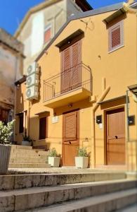 a yellow building with stairs in front of it at Loft Pozzillo in Monreale
