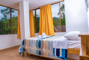 1 dormitorio con cama y ventana grande en Mindoxtrem Birds, en Mindo