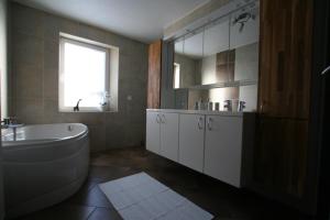 a bathroom with a tub and a sink and a mirror at Gite L'Abeille 
