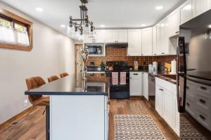 a kitchen with white cabinets and a black refrigerator at Stylish Uptown Butte Condo - 632 in Butte
