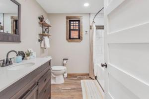 a white bathroom with a toilet and a sink at Stylish Uptown Butte Condo - 632 in Butte