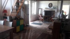 ein Zimmer mit einer Treppe und ein Wohnzimmer mit einem Tisch in der Unterkunft Sous les chênes – Gîte nature dans le Berry Sud in Saint-Saturnin