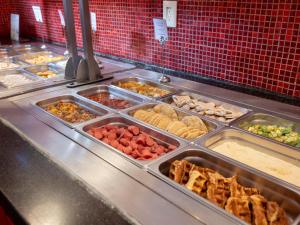 a buffet line with many trays of food at Ramada Encore by Wyndham Queretaro in Querétaro