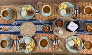 a wooden table with plates of food and bowls of food at Ecohotel Luzul in Nuquí