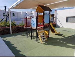 a playground with a slide and a play structure at JUMA HOLIDAYS in Puerto del Carmen