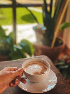 a person holding a cup of coffee on a table at Quinta Amarela - B&B in Nazaré