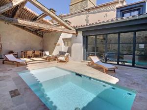 una piscina en un patio con sillas y mesa en Hidden Oasis - Maison de caractère avec piscine, en Azille
