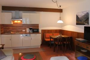 a kitchen and living room with a table and a kitchen and a dining room at AppHaus Sonne in Heiligenblut